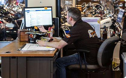 Image of a man sitting at a desk and looking at a computer monitor. Image of a man sitting at a desk and looking at a computer monitor.