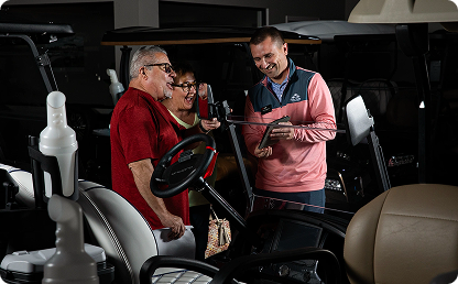 Image of a man holding a tablet up to two customers. Image of a man holding a tablet up to two customers.