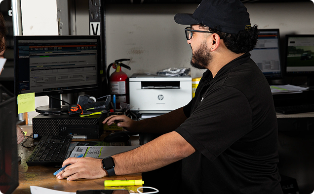 An employee using a computer at their desk. An employee using a computer at their desk.