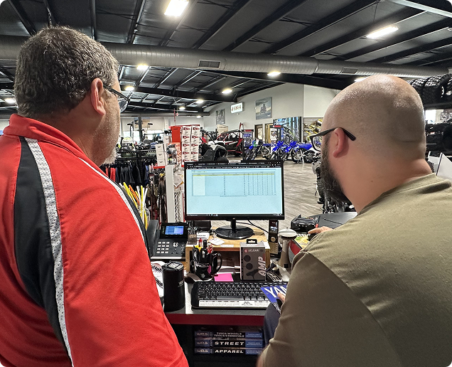 Two Lightspeed employees looking at a monitor on a store floor. Two Lightspeed employees looking at a monitor on a store floor.